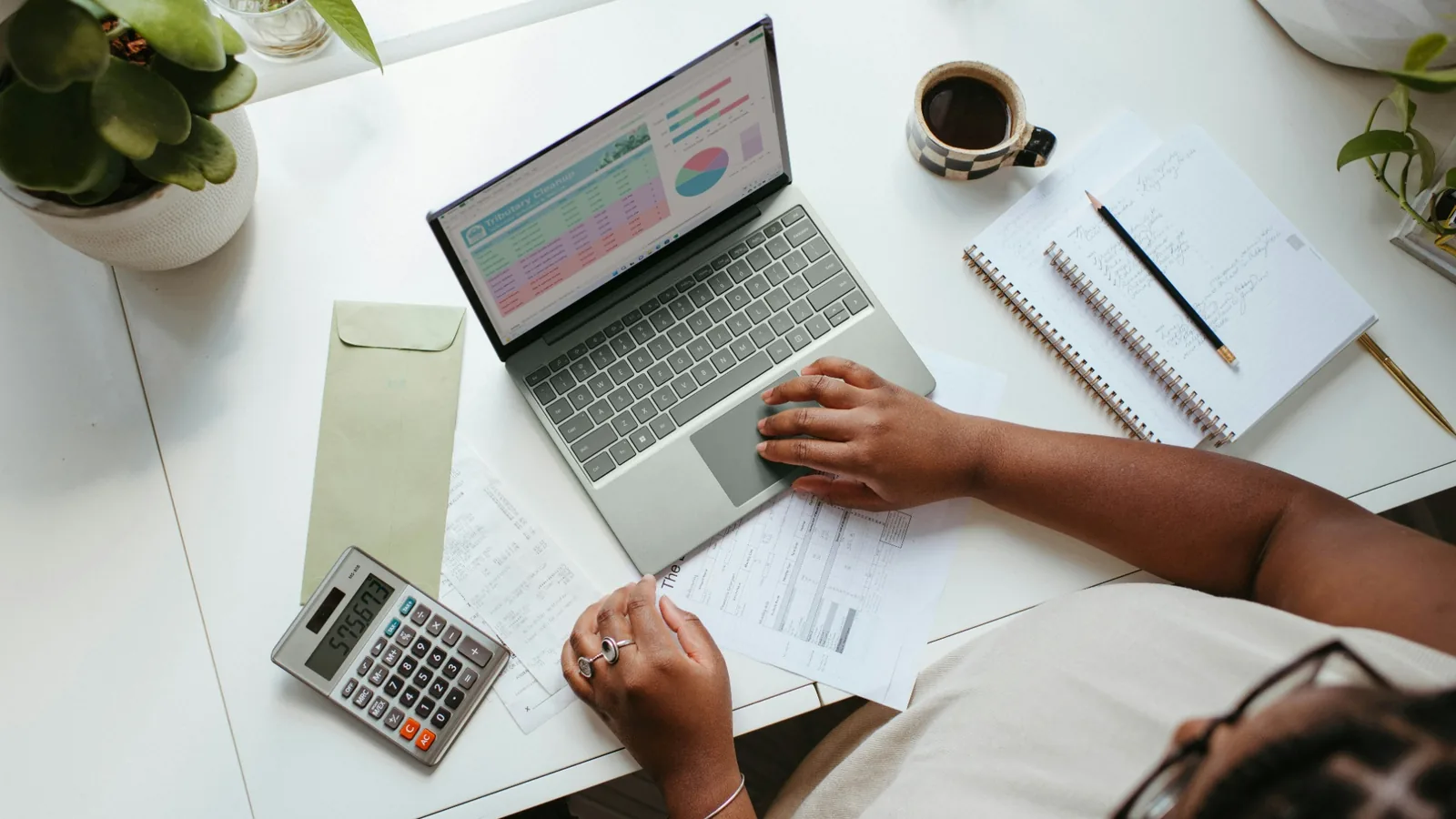 Financieel overzicht maken met laptop, rekenmachine en administratie